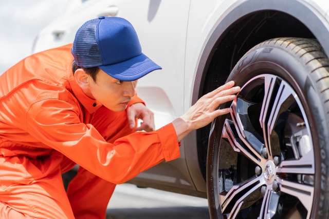 タイヤをチェックする自動車整備士