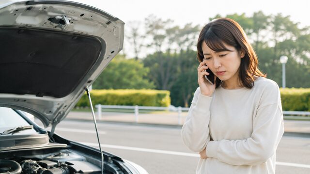 車の故障で困惑する女性