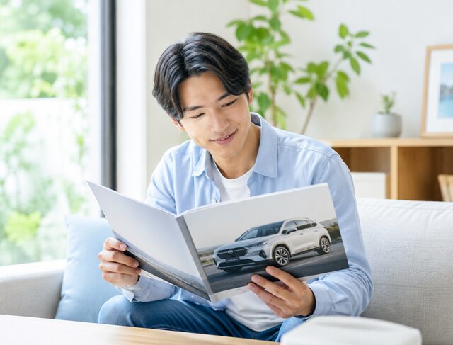 車のカタログを読む男性