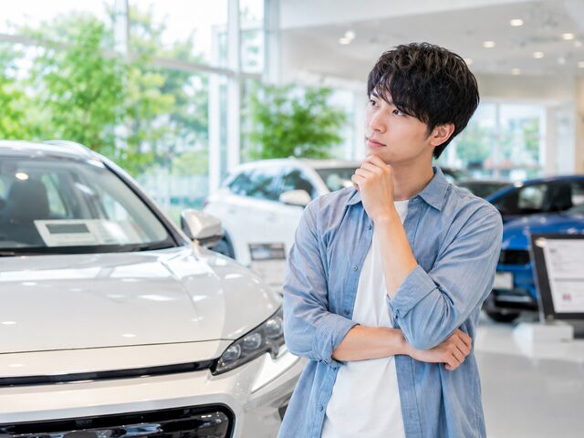 車のショールームで悩む男性