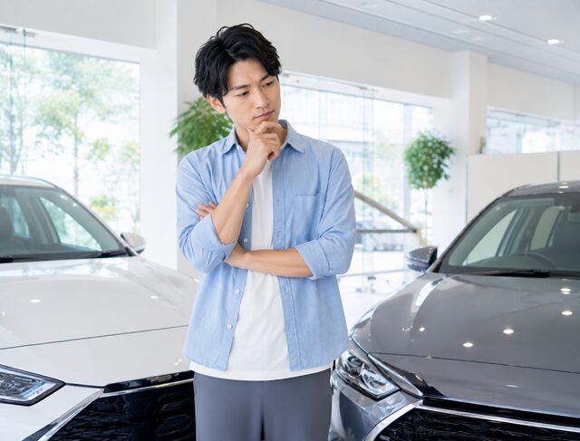 車のショールームで悩む男性